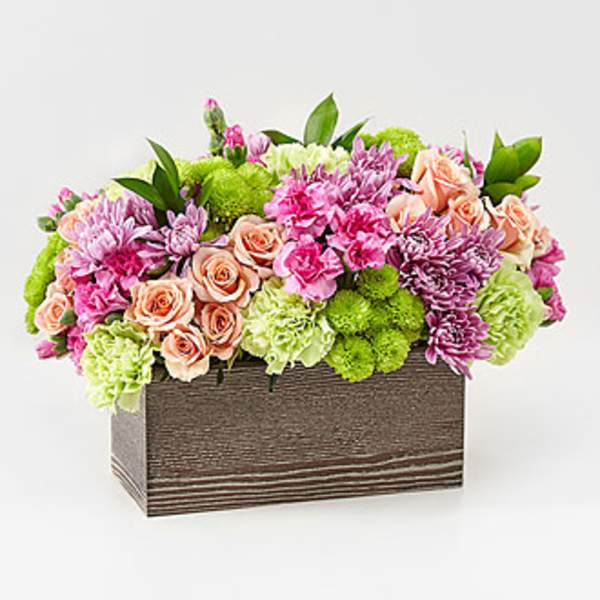Mixed pink and peach flowers in a rectangular wooden box