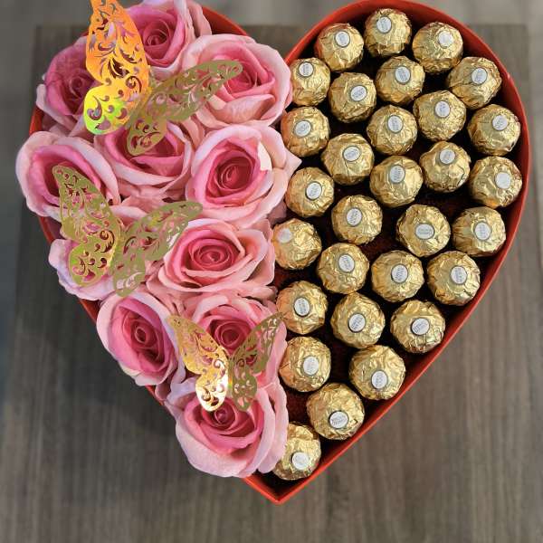 Heart-shaped box with pink roses and gold-wrapped chocolates