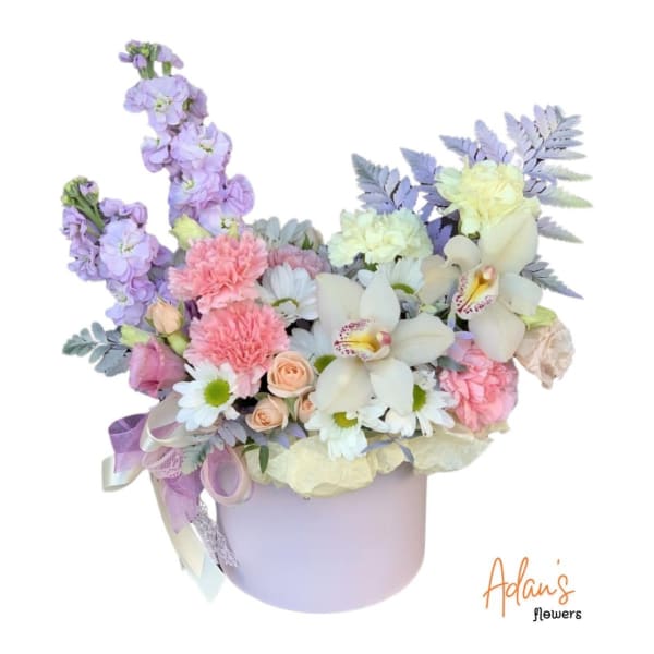 Pastel flower arrangement in a lavender hat box with ribbon