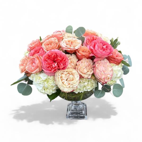 Pink and peach roses arranged in a clear glass vase