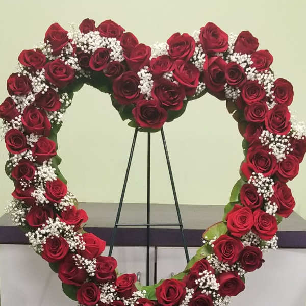 Heart-shaped rose wreath on a black stand
