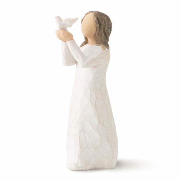 Angel figurine in a white dress holding a small bird