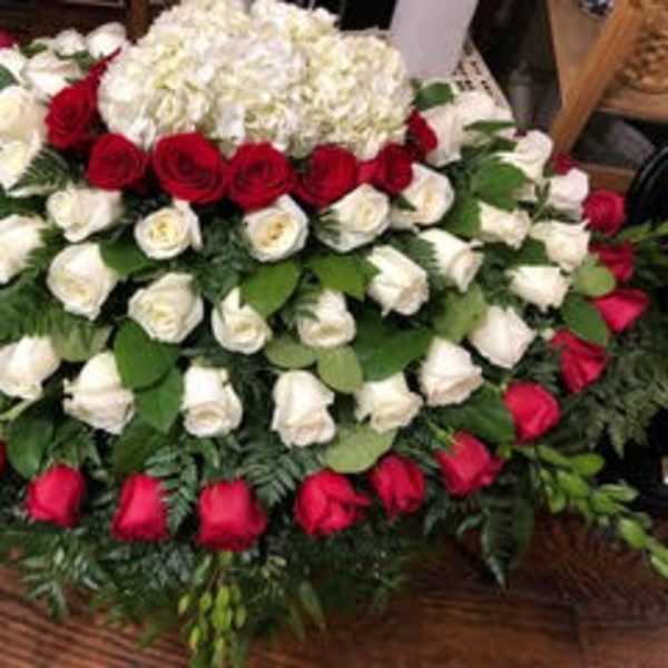 Large red and white rose arrangement with hydrangea on a table
