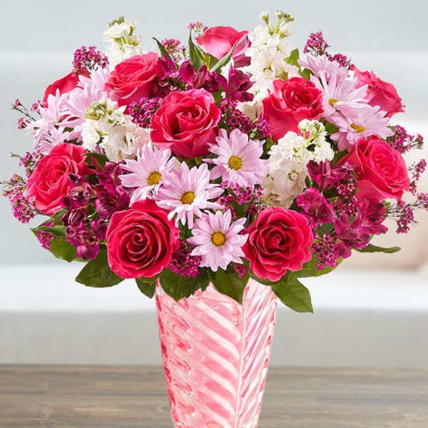 Pink roses and daisies in a striped glass vase