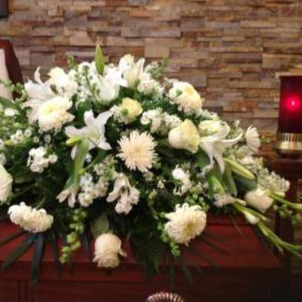 White funeral casket spray with lilies and chrysanthemums