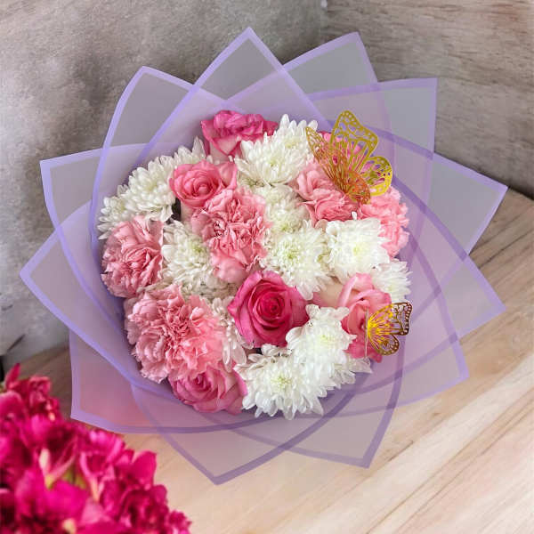 Pink and white bouquet wrapped in lavender paper
