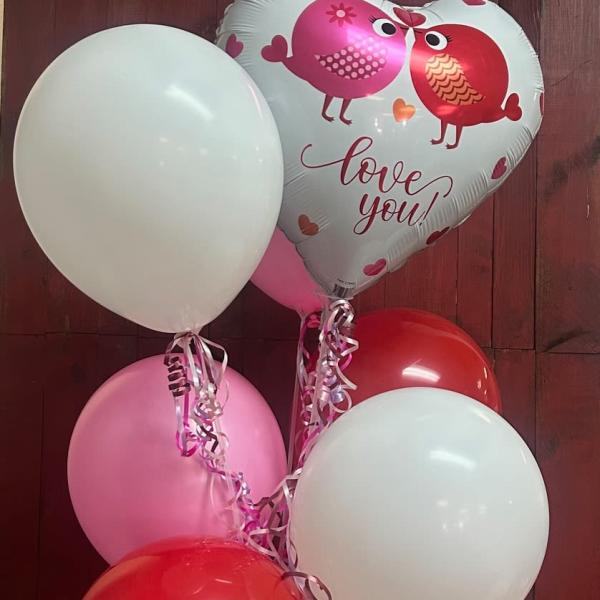 Heart-shaped love-you balloon with several pink, red, and white balloons
