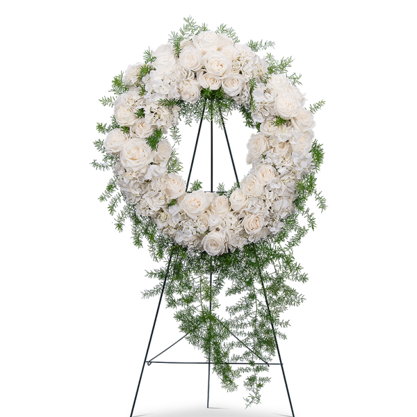 White rose and hydrangea funeral wreath on a stand