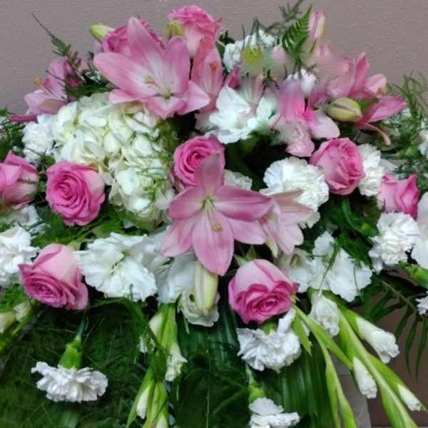 Pink and white floral spray with lilies, roses, and carnations