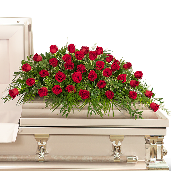 Red roses arranged on a white casket