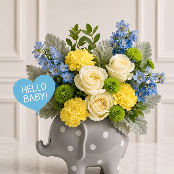 Bouquet of blue, yellow, and white flowers in a gray elephant vase with a "Hello Baby!" sign