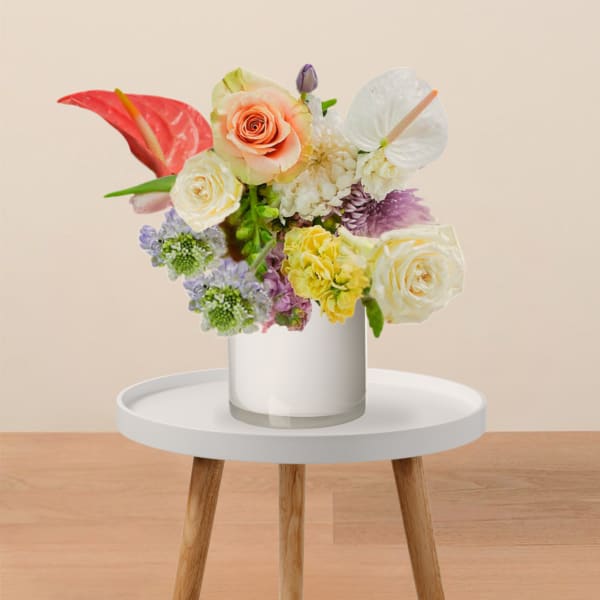 Mixed bouquet in a white vase with roses and anthuriums