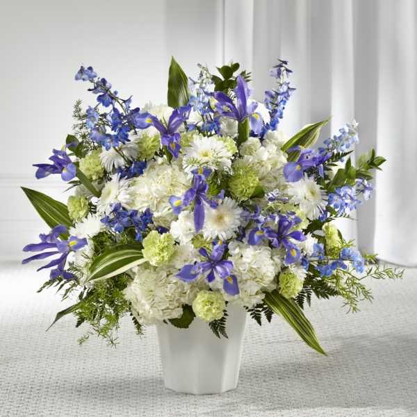 White and purple floral arrangement in a white vase