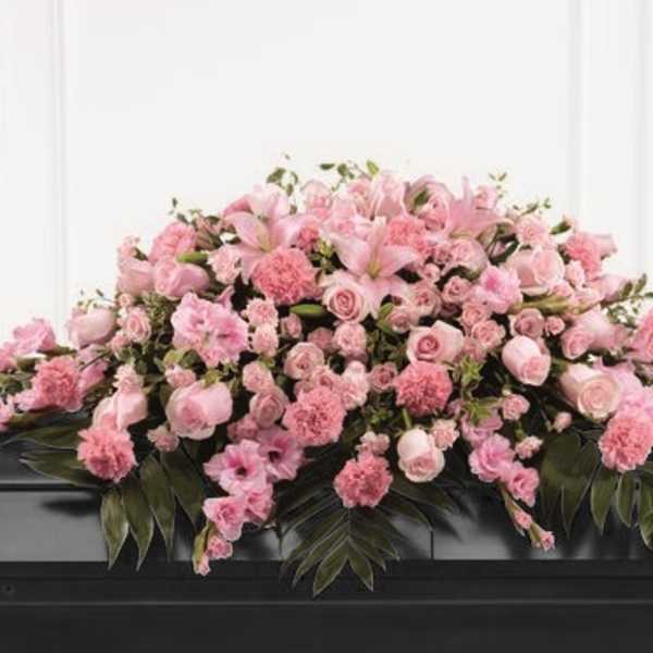 Pink floral casket spray with roses and lilies