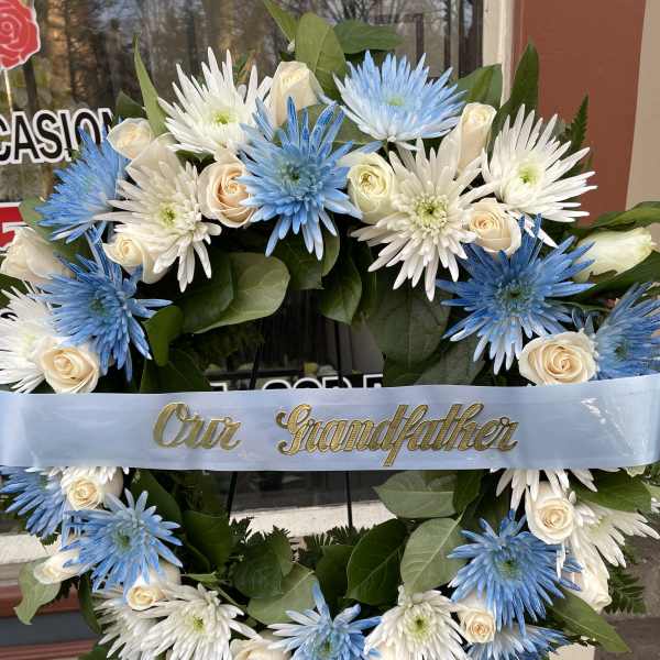 Blue and white floral wreath with a ribbon reading "Our Grandfather"