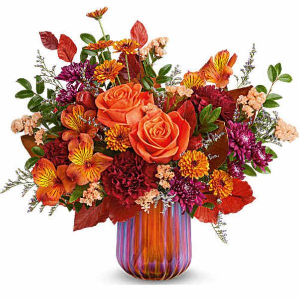Orange roses and mixed autumn flowers in a striped glass vase