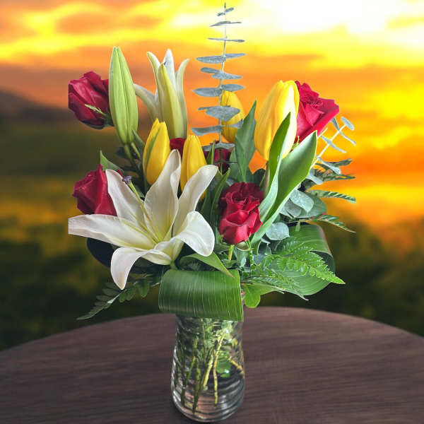 Bouquet of red roses and white lilies in a clear glass vase