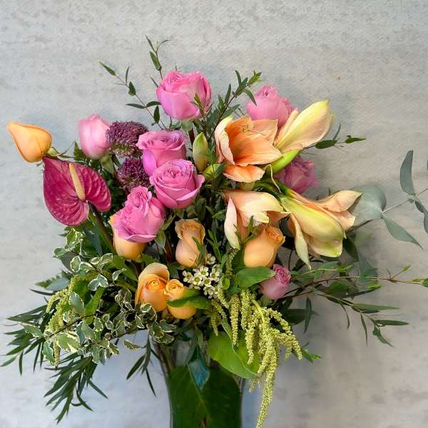 Mixed pink and peach roses in a clear glass vase