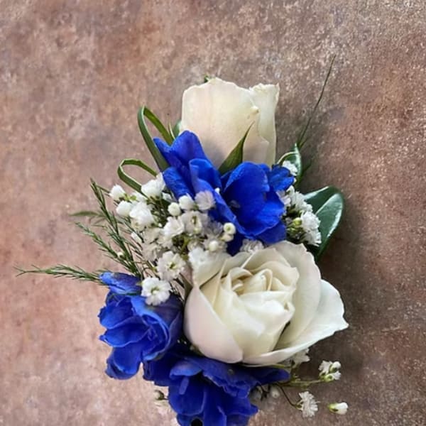 White and blue rose boutonniere with small white filler flowers