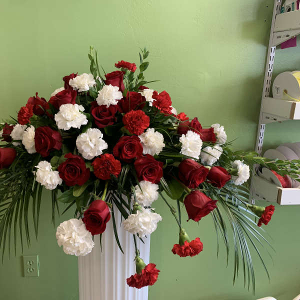Red roses and white carnations in a tall pedestal arrangement