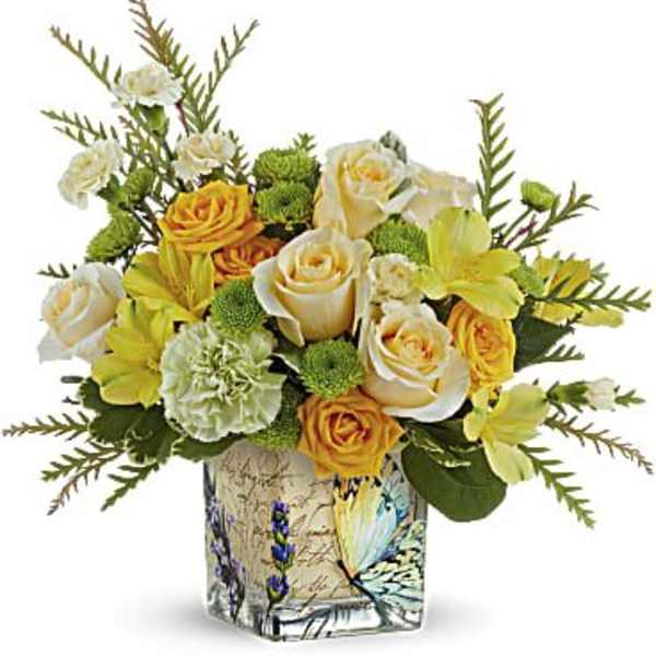 Bouquet of yellow and white roses in a decorative glass vase