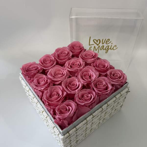 Pink roses arranged in a square gift box with a clear lid