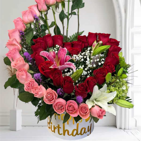 Mixed bouquet of pink and red roses with lilies in a birthday box