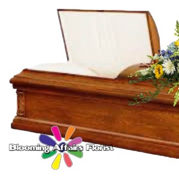 Wooden casket with a mixed floral spray on top
