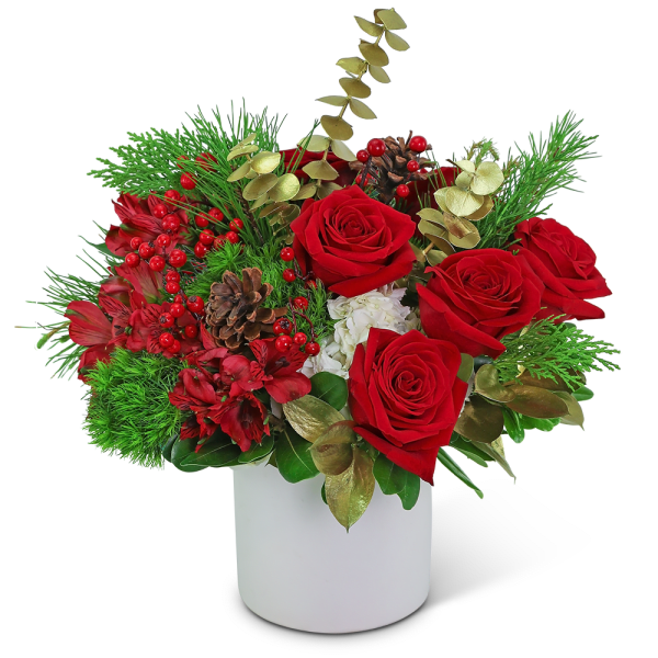 Red roses and berries in a white vase with pinecones and greenery