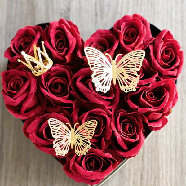 Heart-shaped box filled with red roses and gold butterfly decorations
