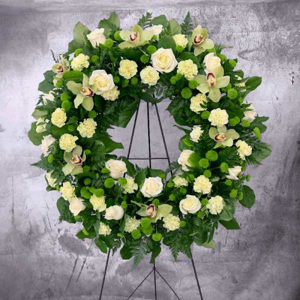Large floral wreath with white roses, pale orchids, and green pom-pom flowers