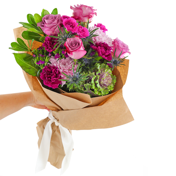 Hand-tied bouquet of pink and purple flowers wrapped in brown paper