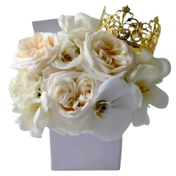 White roses and orchids in a lavender box with a gold crown topper