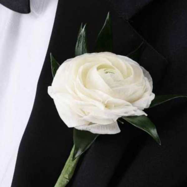White flower boutonniere on a black suit jacket