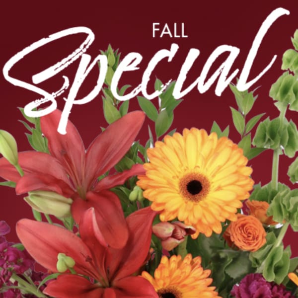 Fall floral arrangement with red lilies, orange gerbera daisies, and roses