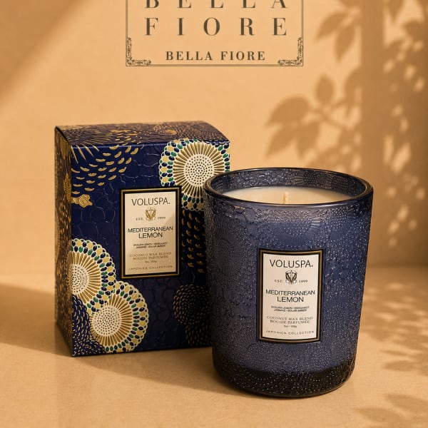 Blue patterned candle in a box beside a matching candle jar