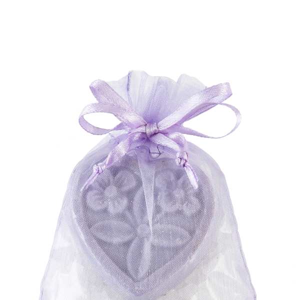 Lavender organza gift bag with a heart-shaped decorative piece and white crystals inside.