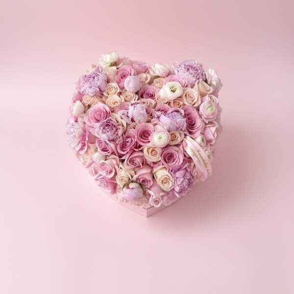 Heart-shaped bouquet of pink and white roses on a pink background