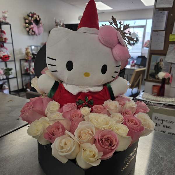 Hello Kitty plush in a red Santa hat surrounded by pink and white roses