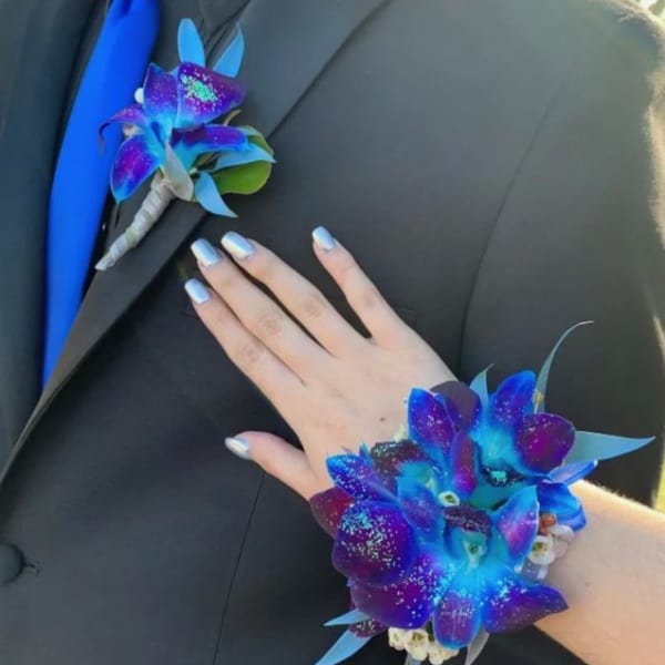 Boutonniere and wrist corsage with vivid blue and purple orchids
