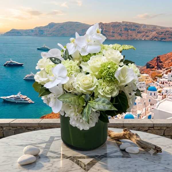White floral arrangement in a dark green vase on a marble table