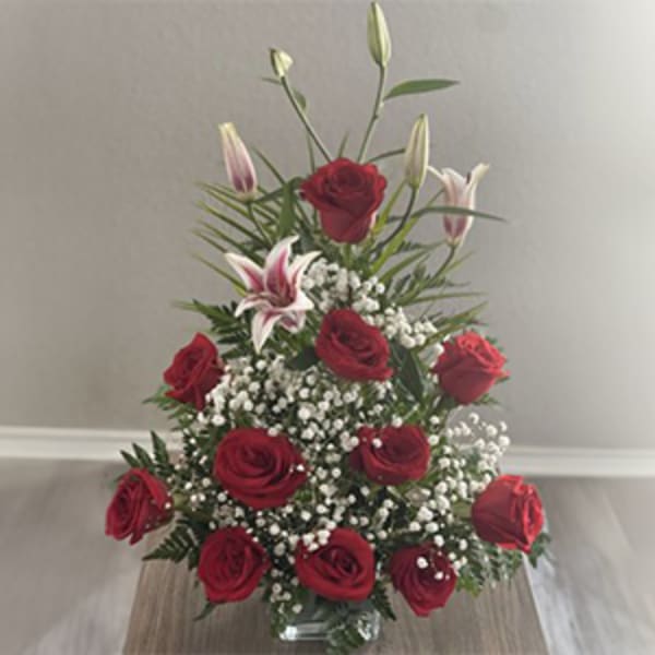 Red roses and white lilies arranged in a clear glass vase