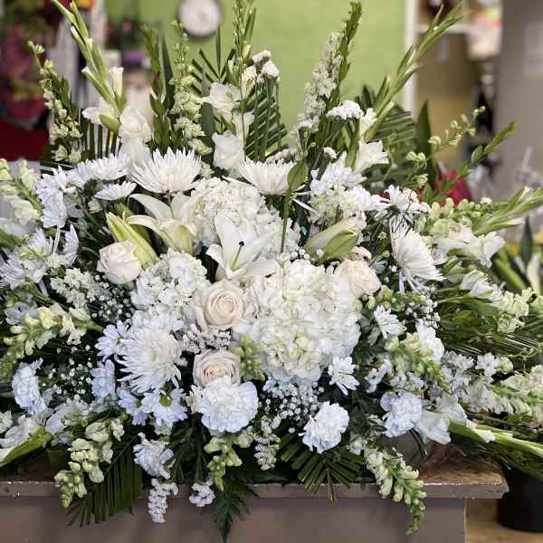 Large white floral spray with lilies, roses, and chrysanthemums