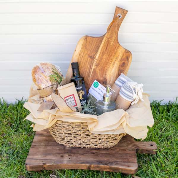 Gift basket with bread, olive oil, soap, and a wooden cutting board