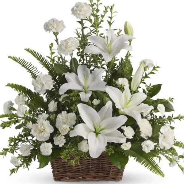 White lilies and carnations arranged in a wicker basket