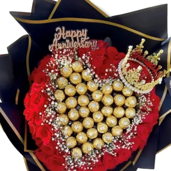 Heart-shaped bouquet of red roses and gold chocolates with a Happy Anniversary topper