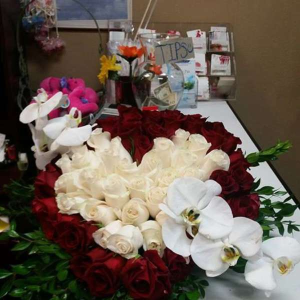 Heart-shaped rose arrangement with white orchids and greenery