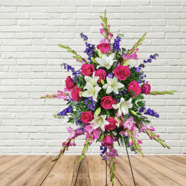 Standing floral spray with pink roses, white lilies, and purple accents