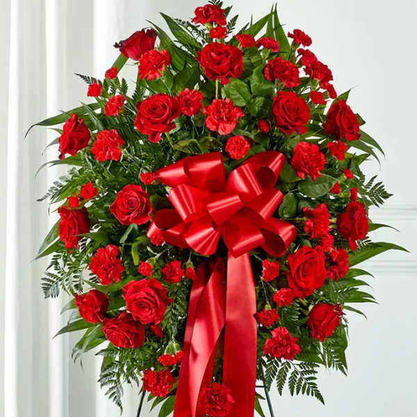 Standing wreath of red roses and carnations with a large red bow
