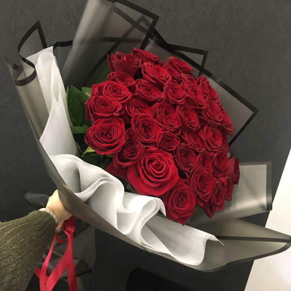 Bouquet of red roses wrapped in black and white paper